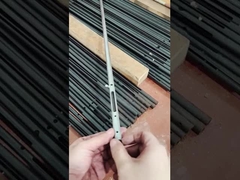 Ein Mann zeigt ein kleines Bauteil aus Kohlenstoffstahlrohr